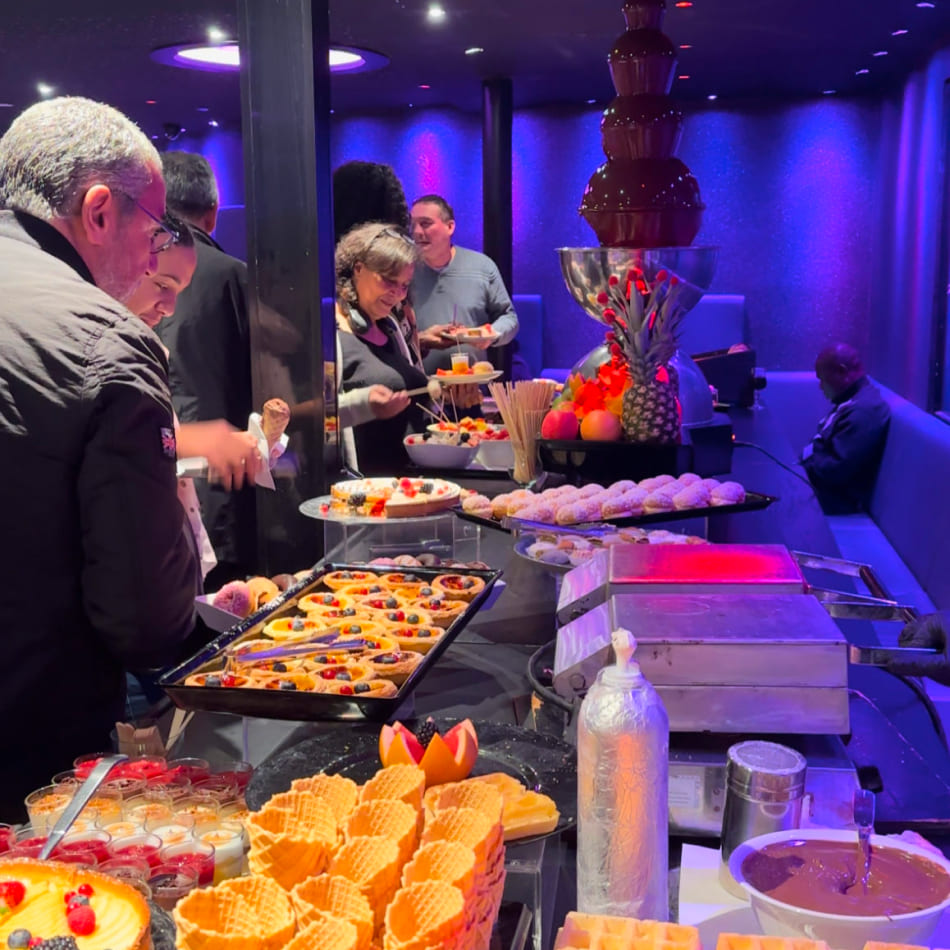 Buffet de desserts variés avec une fontaine de chocolat, des fruits frais et des pâtisseries lors d'un événement festif.