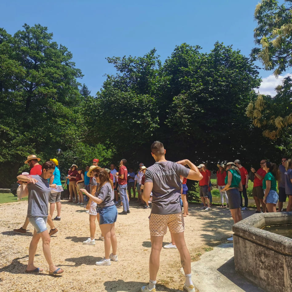 Groupe de personnes participant à une activité de groupe ou un jeu d'équipe dans un parc arboré.