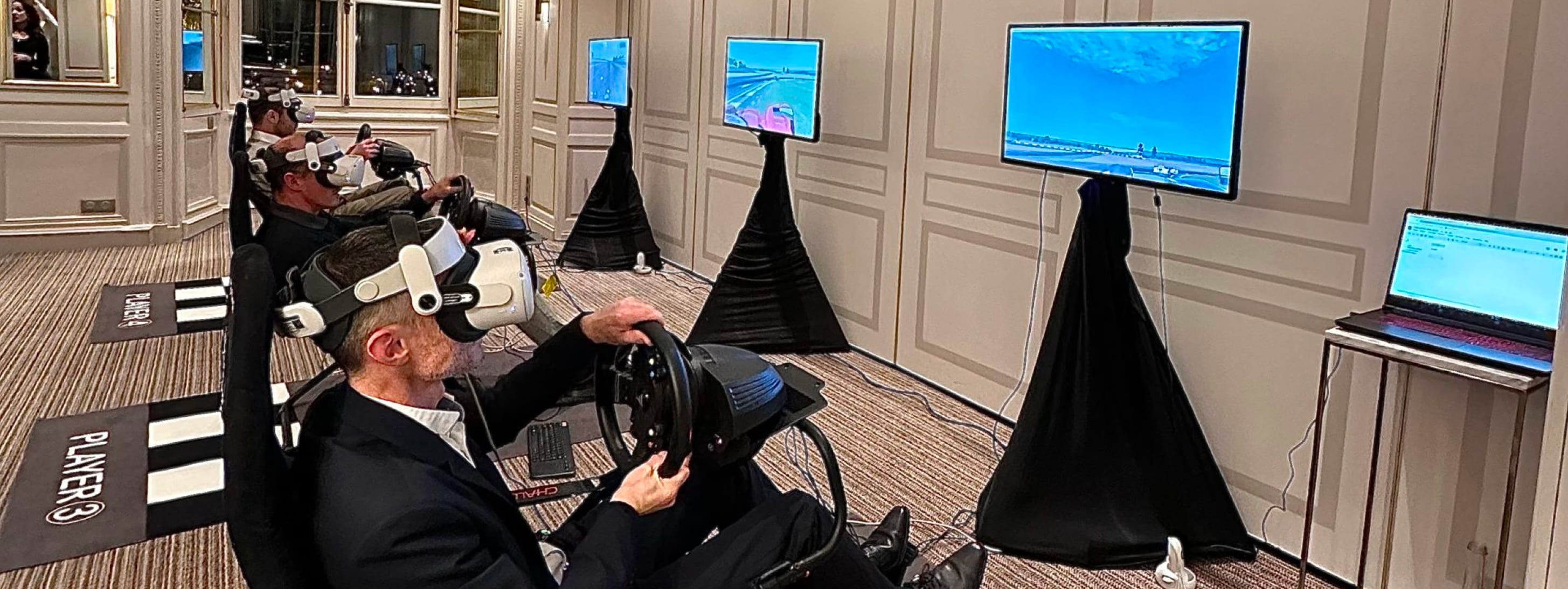 Plusieurs participants testant des simulateurs de conduite avec casques de réalité virtuelle lors d'une animation technologique.