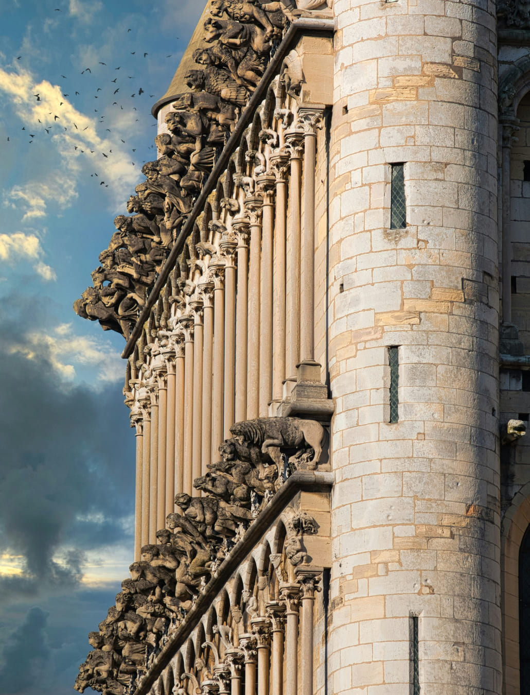 Vue de la Place de la Libération à Dijon au coucher du soleil, montrant le Palais des Ducs de Bourgogne à droite, des maisons à colombages à gauche et des jets d'eau au premier plan.