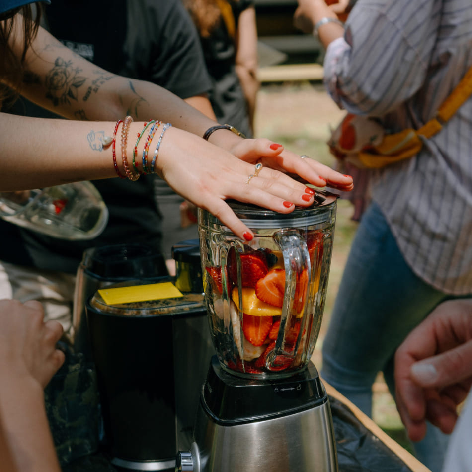 Gros plan sur la préparation d'un smoothie frais aux fruits rouges dans un blender lors d'un atelier culinaire.