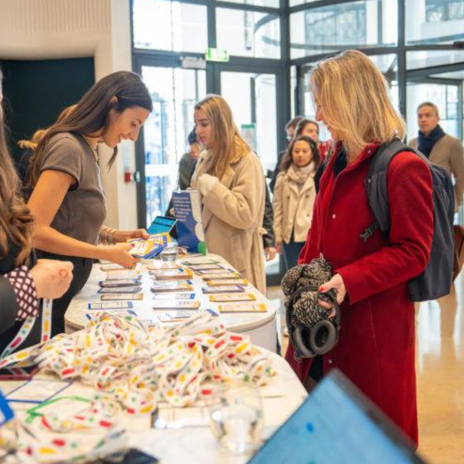 Accueil et enregistrement des participants à un comptoir d'entrée lors d'un événement professionnel.