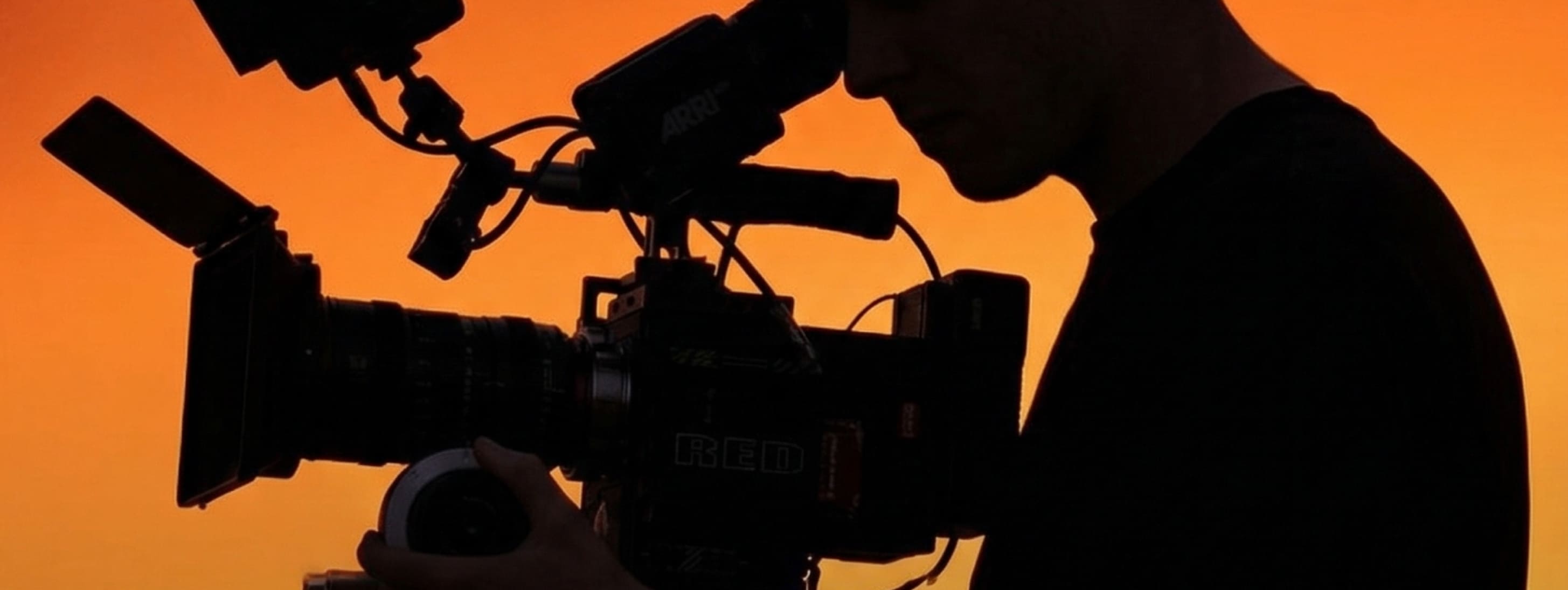Vidéaste l'oeil à la caméra sur fond jaune doré